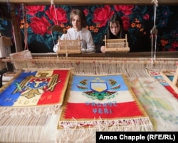 Schoolgirls weave carpets, which is a part of their school curriculum, in the Gagauzian village of Tomai.