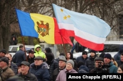 People waving Moldovan (left) and Gagauzian flags listen to Nikolai Dudoglo speak in Comrat on March 18.