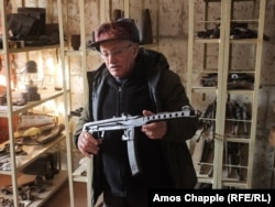 Giorgi Tucan, the manager of the Comrat Regional Historical Museum, shows off a Soviet-made PPS submachine gun.