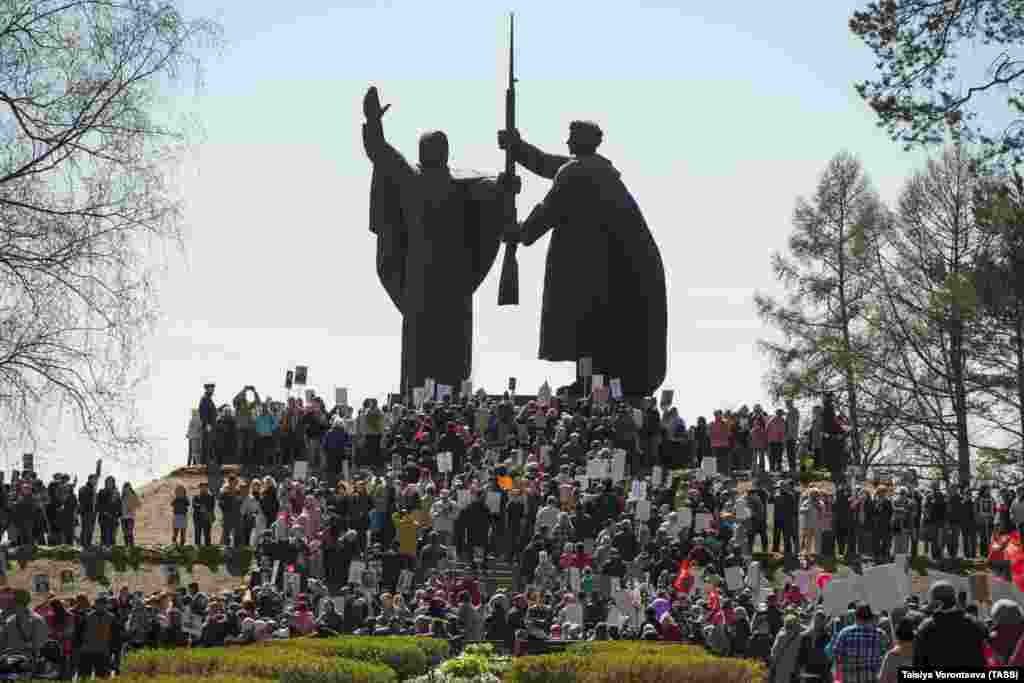 People with portraits of their relatives who fought in World War II gather at the monument, called Motherland Hands A Weapon To Her Son, in the city of Tomsk on May 9, 2019, to mark the 74th anniversary of Soviet victory in the Great Patriotic War.