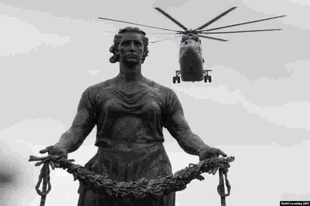 A military helicopter flies over a statue of the Mother Motherland at the Piskaryovskoye Memorial Cemetery in St. Petersburg during a rehearsal for the 2020 Victory Day parade. The monument pays tribute to the more than half a million Leningrad siege victims who were killed during World War II. The military parade to mark the 75th anniversary of the victory over Nazi Germany on May 9 is postponed due to the coronavirus outbreak, leaving only a flyby.