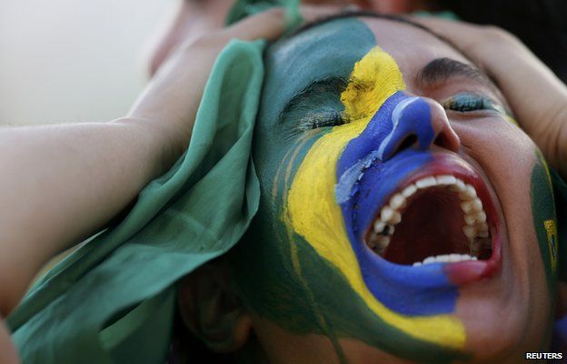 A Brazil fan holds her head in despair during the semi-final defeat to Germany
