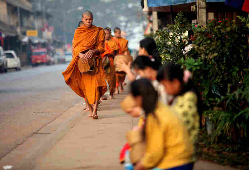 Buddhist monks receive alms at sunrise in Luang Prabang.
