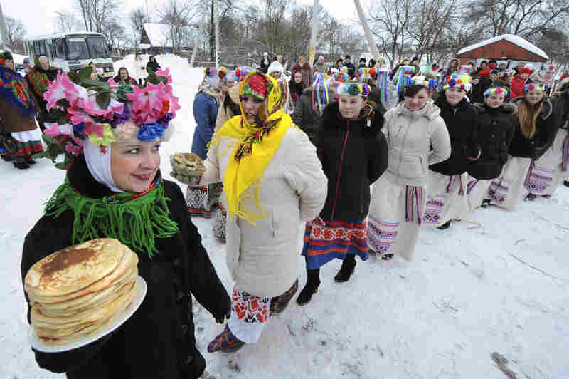 Belarusian women in festive costumes welcome the coming of spring with stacks of blinis during the 2010 Maslenitsa celebrations. The holiday is celebrated in Slavic Orthodox European countries.