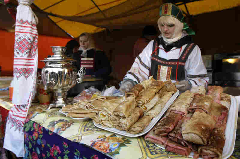 A vendor sells blini at a booth camp just outside the Kremlin in Moscow during Maslenitsa, February 2009. Each day of the week calls for prescribed activities. For example, on Sunday, the final day of the event, people are supposed to seek forgiveness from friends and strangers.