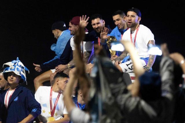 Argentina's forward Lionel Messi (C) and Argentina's midfielder Angel Di Maria (2nd R) celebrate on board a bus after winning the Qatar 2022 World Cup (AFP via Getty Images)