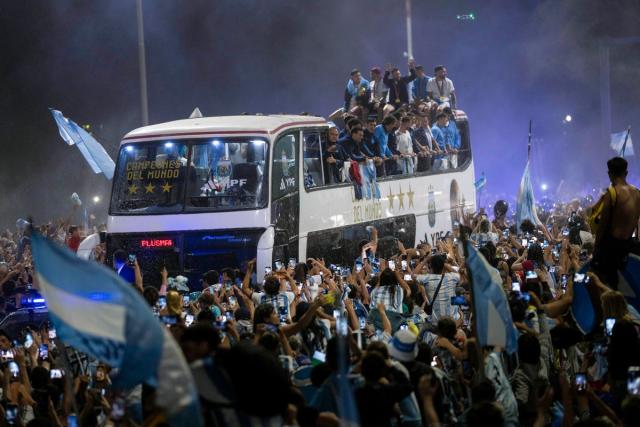 Soccer fans surround the bus taking the Argentine soccer team that won the World Cup to the Argentina Soccer Association grounds where they will spend the night (AP)