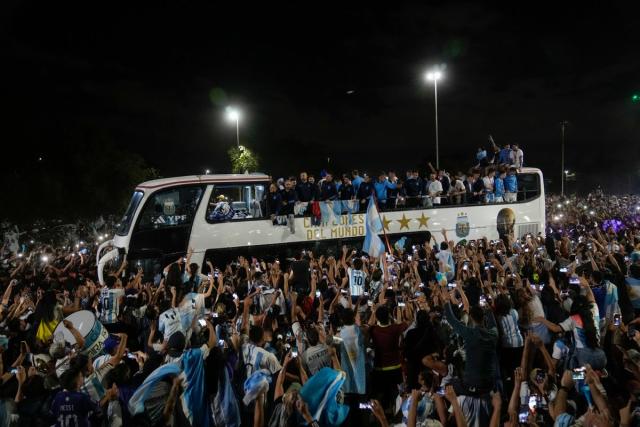 Fans welcome home the players from the Argentine soccer team that won the World Cup after they landed at Ezeiza airport in Buenos Aires (AP)