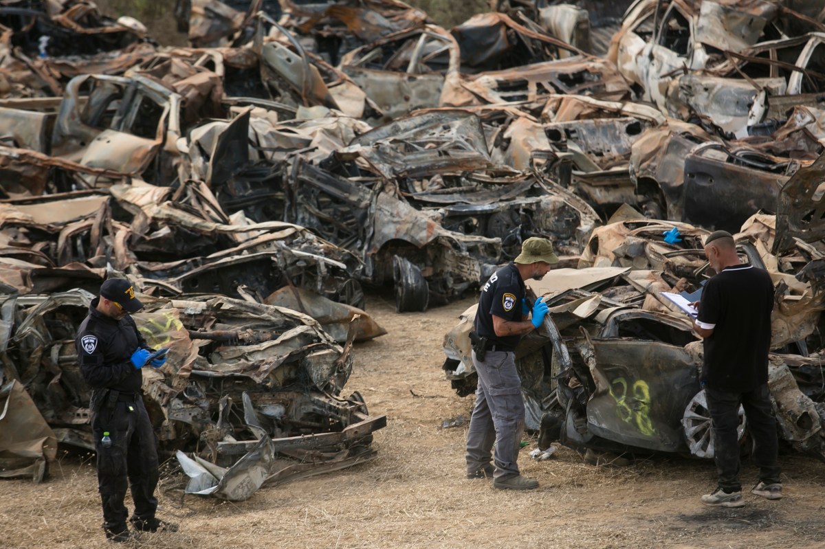 NETIVOT, ISRAEL - OCTOBER 31:  Police officers check cars that were burnt during Hamas' attack on the Israeli south border at a site where police collect damaged and burnt cars from the attack on October 31, 2023 in Netivot, Israel. As Israel's response to Hamas's Oct 7 attacks entered its fourth week, the Israeli PM said the current war would be a long one and would amount to a 