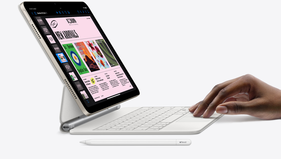 Vedere laterală a unui iPad Air pe care e afișată aplicația Keynote. Acesta e atașat la tastatura Magic Keyboard. O mână e așezată pe trackpad, cu un Apple Pencil în apropiere.