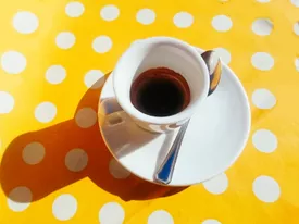 Shot of espresso on yellow tablecloth